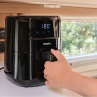 Mestic Airfryer MA-300 auf der Arbeitsplatte einer Wohnmobilküche, eine Hand öffnet die Schublade